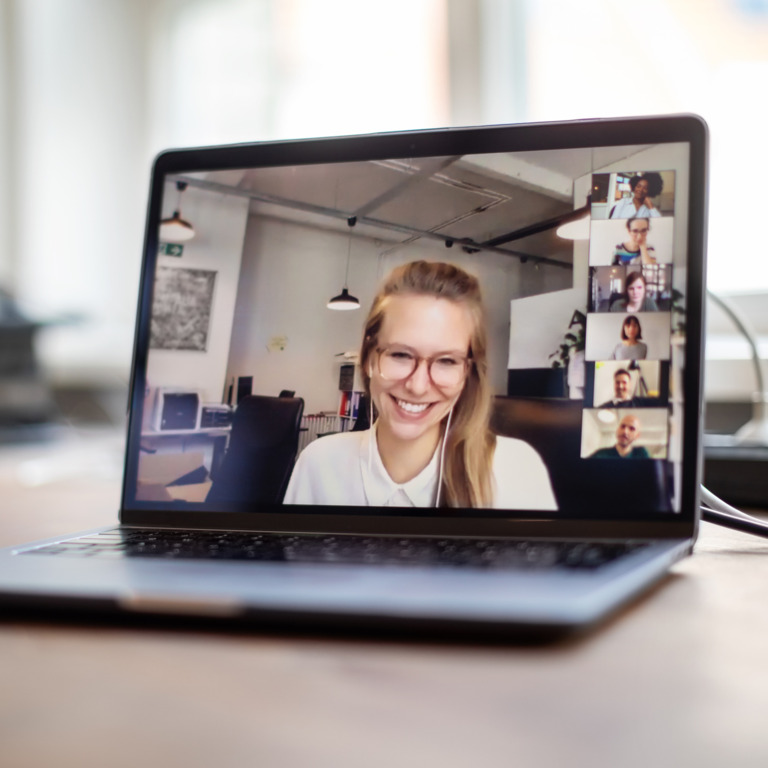 Eine junge Frau ist auf dem Bildschirm eines Laptop im Videocall zu sehen.