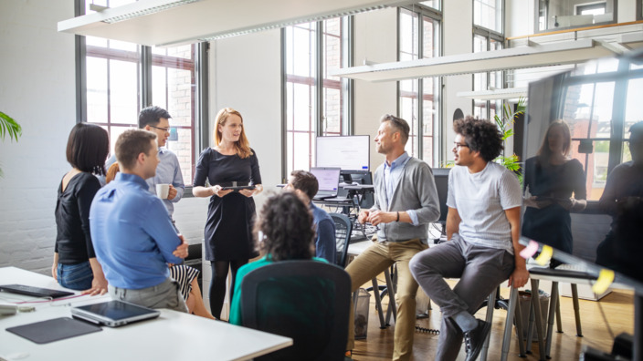 Gruppe von Arbeitskollegen im Gespräch im Büro