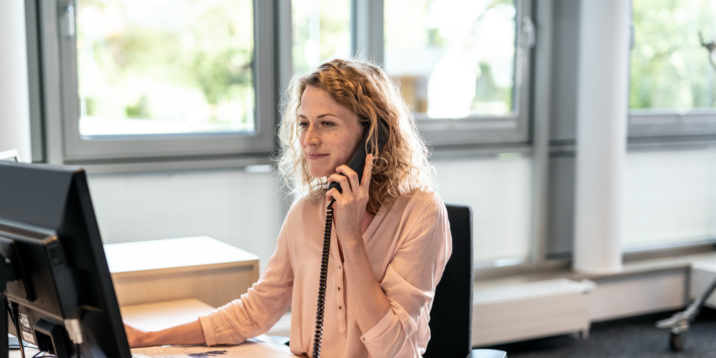 Frau im Büro am Telefon 