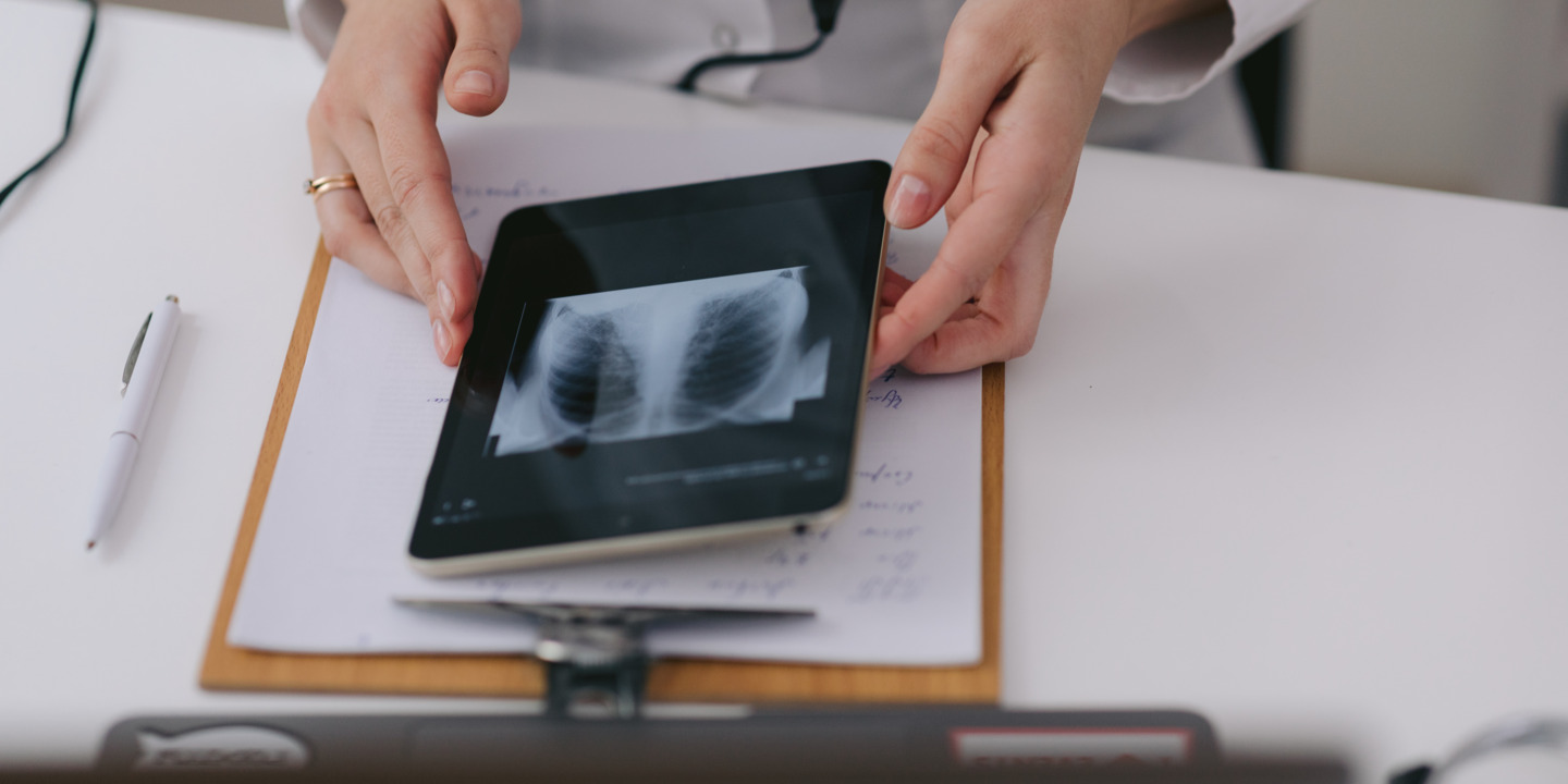 Ärztin hält Tablet mit Röntgenaufnahme