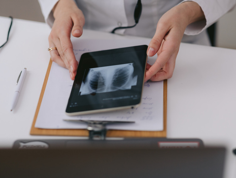 Ärztin hält Tablet mit Röntgenaufnahme 