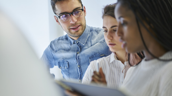 Drei Personen im Gespräch im Büro