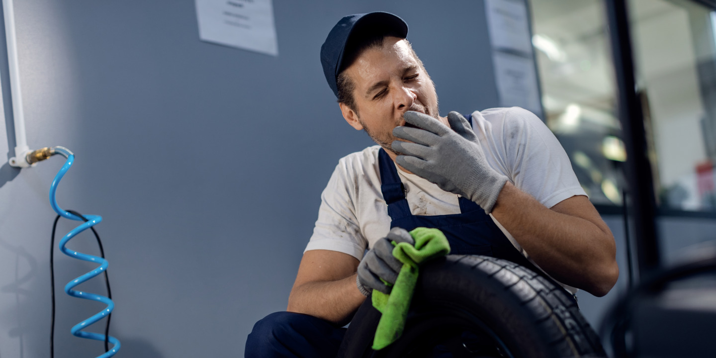 Mechaniker gähnt bei der Arbeit