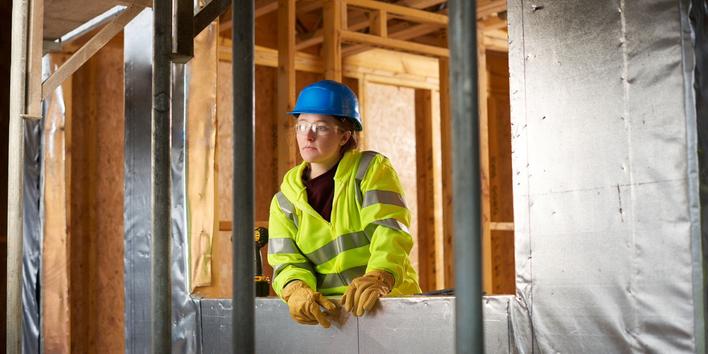 Junge Auszubildene im Handwerk guckt nachdenklich