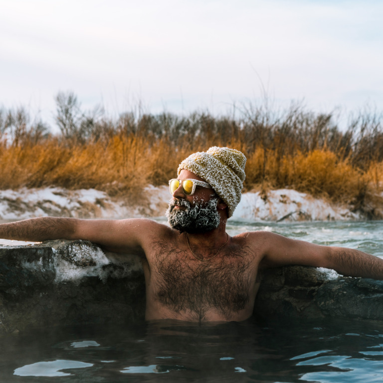 Mann mit Mütze und Sonnenbrille beim Eisbaden