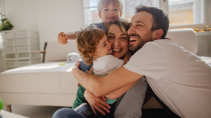 vierköpfige Familie nimmt sich gegenseitig in den Arm