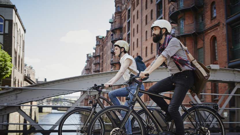 Fahrradfahrer und Fahrradfahrerin fahren über Brücke