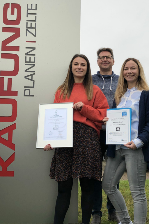 Gruppenbild vor dem Firmenschild der Firma Kaufung
