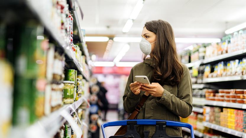 Frau mit FFP2-Maske kauft im Supermarkt ein.