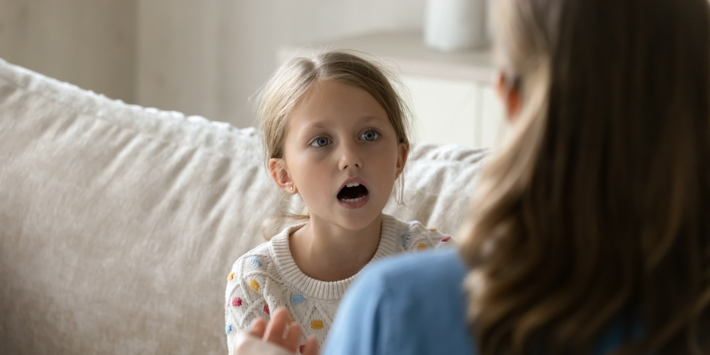 Mädchen macht zuhause Sprechübungen mit ihrer Mutter