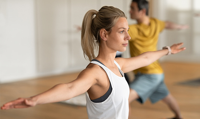 Junge Frau bei Dehnübungen im Yoga-Kurs