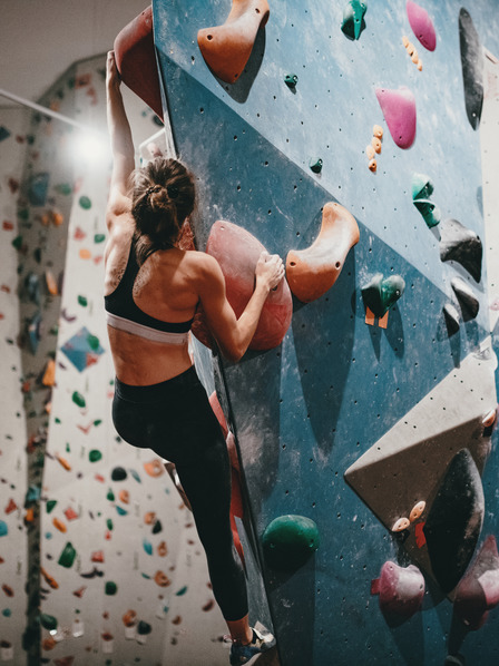 Frau klettert in Boulderhalle