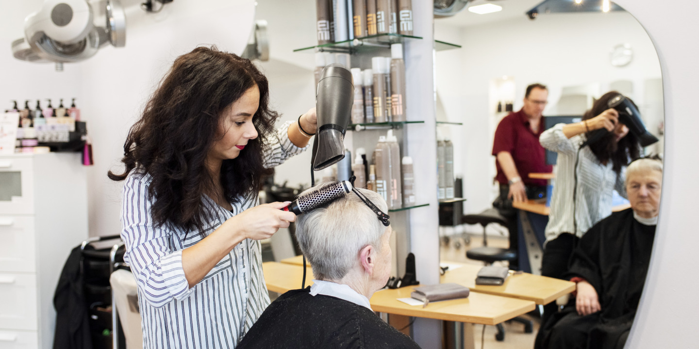 Friseurin schneidet Kundin die Haare