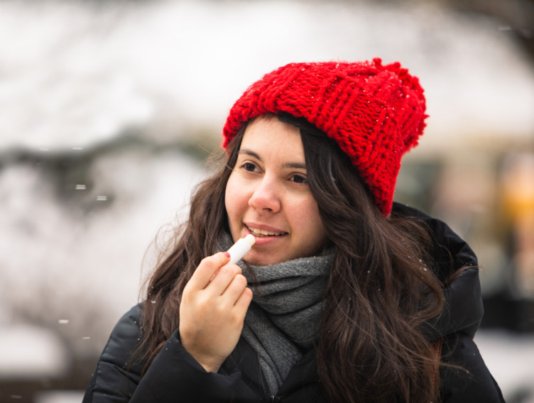 Frau pflegt ihre Lippen im Winter
