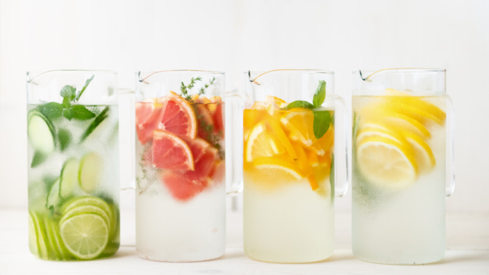 Vier Gläser mit Wasser und Obst