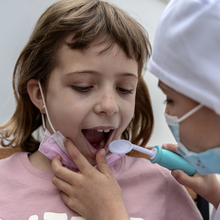 Kind lässt sich beim Zahnarzt auf Kreidezähne untersuchen