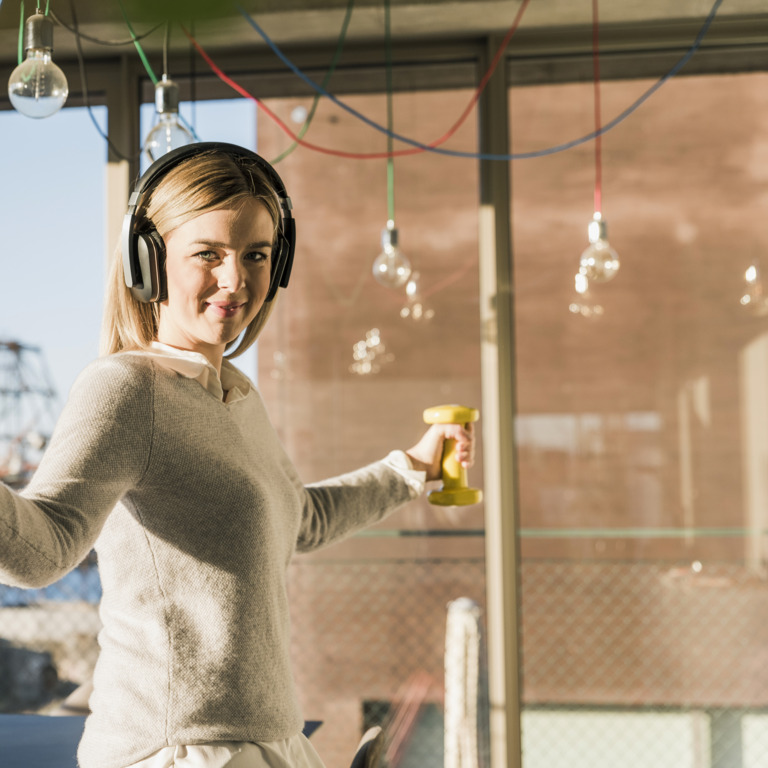 Frau nutzt eine Pause im Büro für eine Trainingseinheit mit Wini-Weights