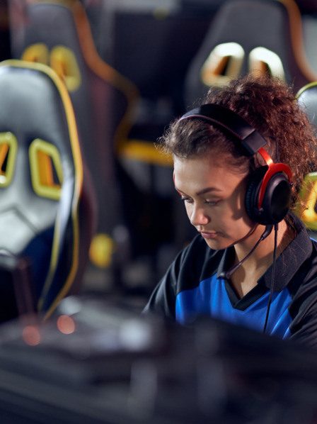 Junge Frau sitzt bei einem Gaming Wettbewerb und spielt