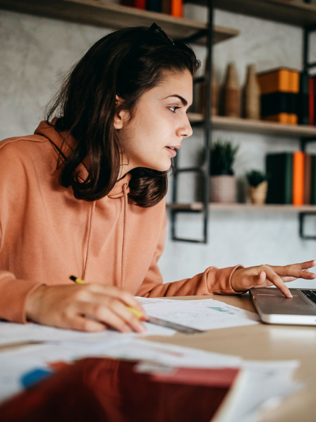 Auszubildende sitzt am Schreibtisch und macht ihre Steuererklärung