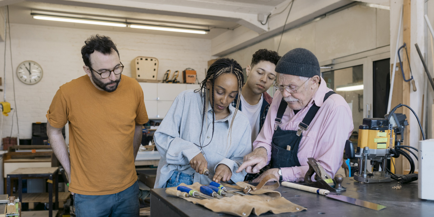 Diverse Handwerker:innen arbeiten zusammen in der Werkstatt