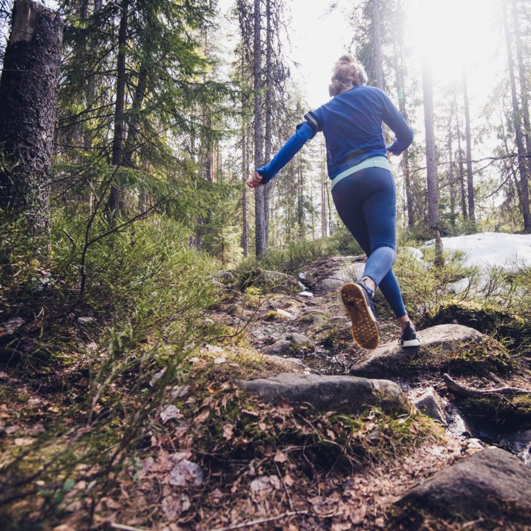 Trailrunnerin läuft durch den Wald