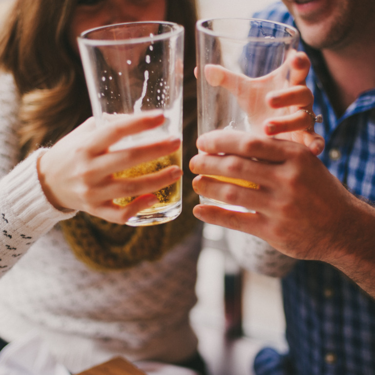Paar stößt mit zwei Gläsern Bier an