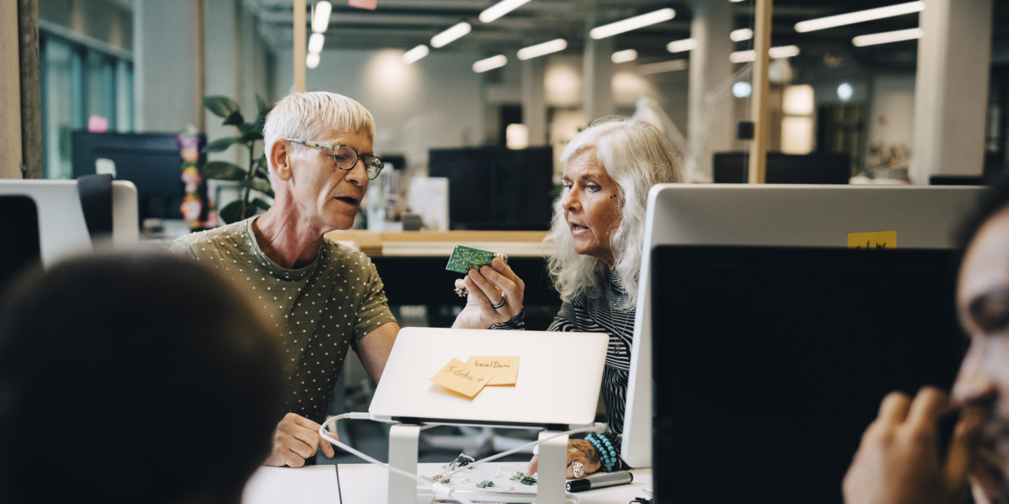 Zwei ältere Personen arbeiten im Büro zusammen