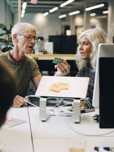 Zwei ältere Personen arbeiten im Büro zusammen