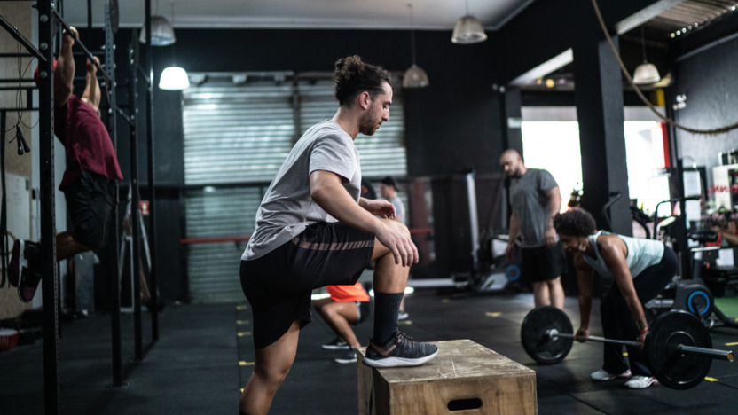 Person trainiert im Fitnessstudio mit unterschiedlichen Sportgeräten