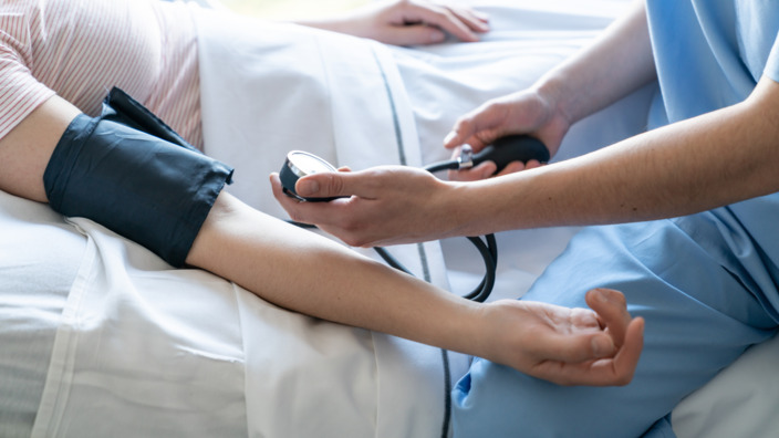 Krankenpfleger misst den Blutdruck eines Patienten