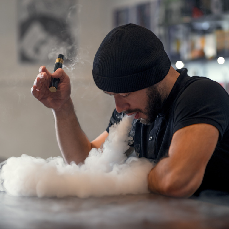 Raucher atmet den Dampf einer E-Zigarette aus