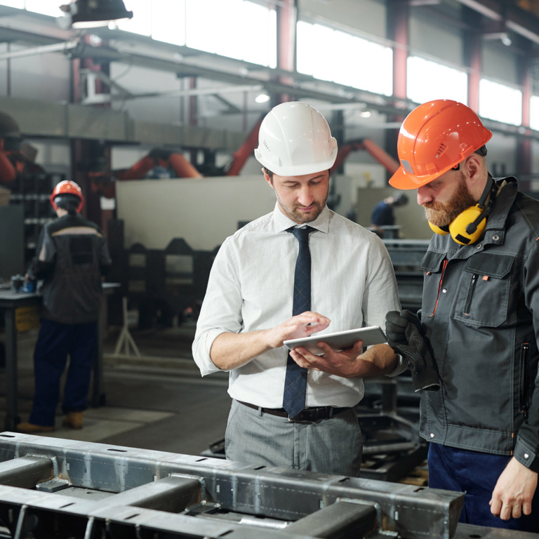 Handwerker plant mit Chef Arbeitszeiten in Fabrik