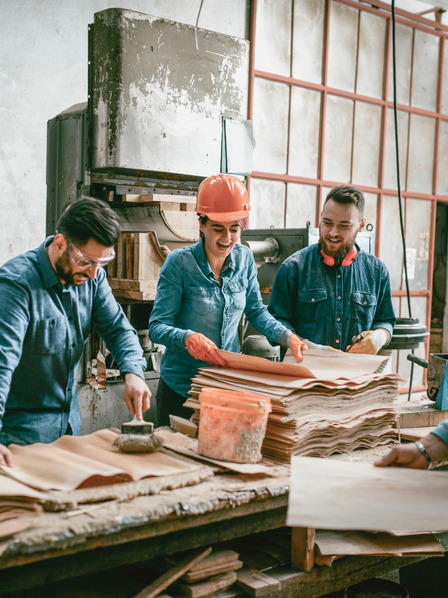 Vier Handwerker lachen zusammen in der Werkstatt