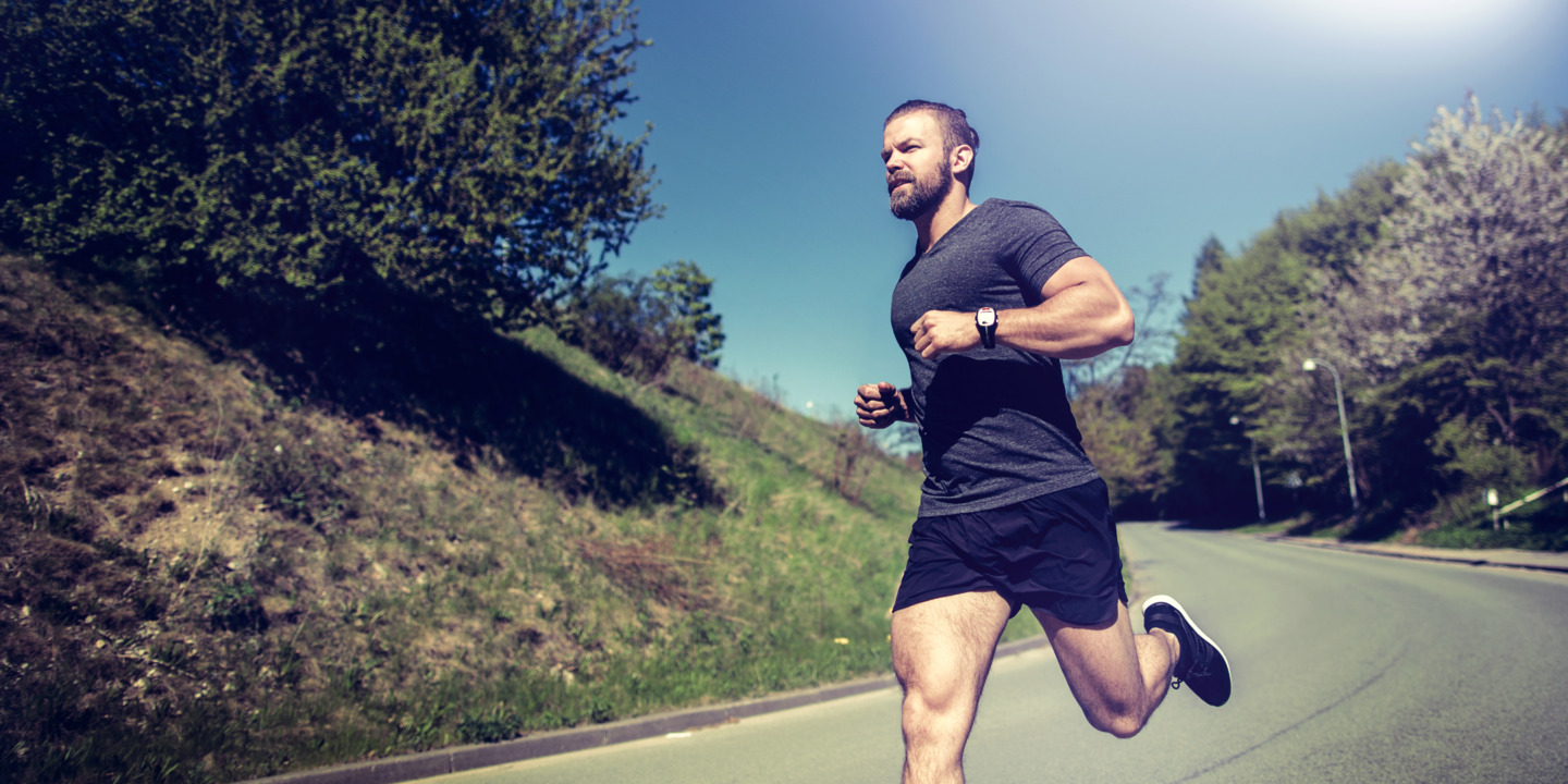 Jogger läuft auf einer Strasse im Frühling