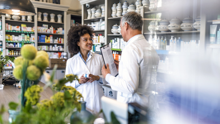 Zwei Apotheker:innen im Gespräch im Laden