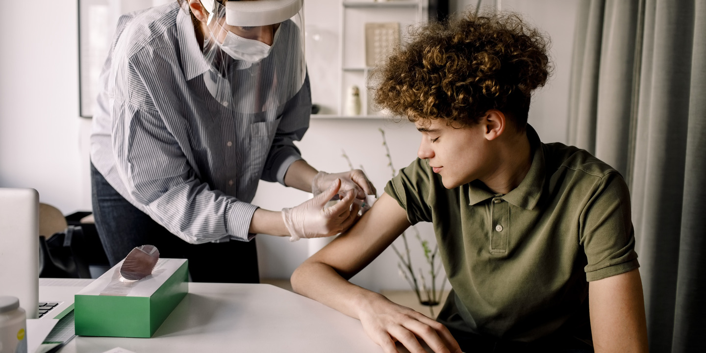 Junger Mann bekommt von seiner Ärztin eine HPV Impfung 