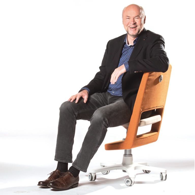 Martin Moll sitzt auf einem Bürostuhl