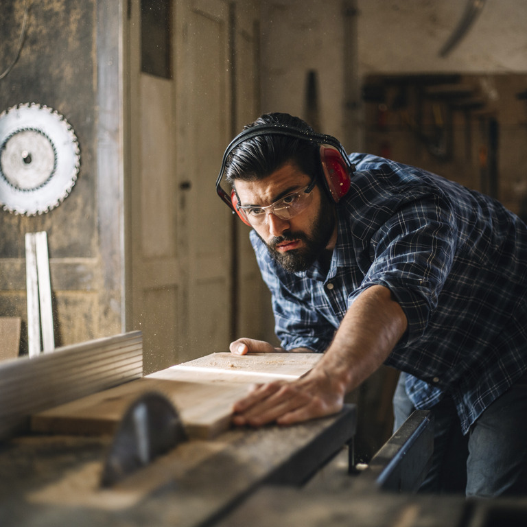 Tischler schneidet Holzbrett in Werkstatt