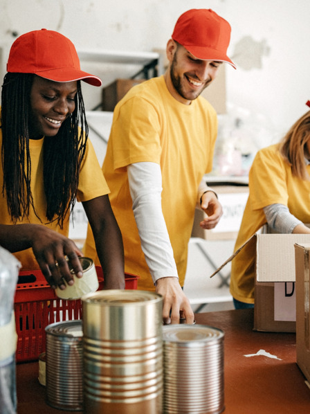 Junge Erwachsene voluntieren und helfen mit Lebensmitteln und packen.