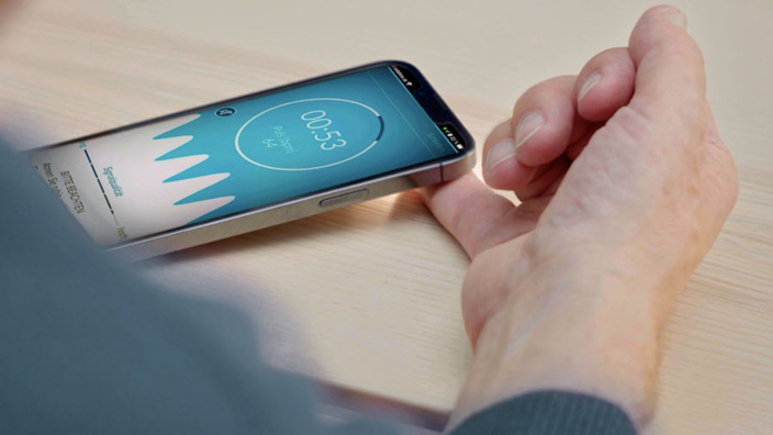kleiner Finger eines Patienten liegt auf der Kamera seines Smartphones, über das sein Blutdruck gemessen wird