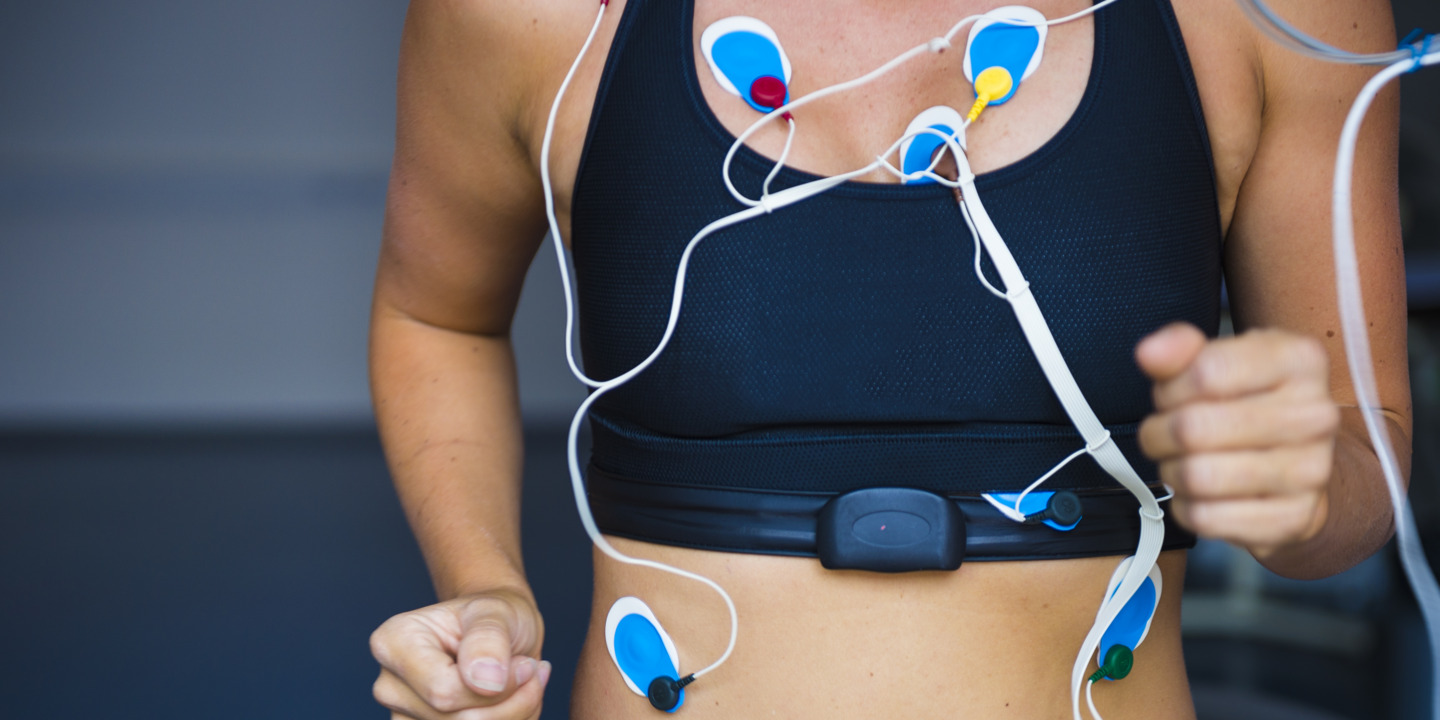 Frau läuft auf einem Laufband und ist an ein Belastungs-EKG angeschlossen