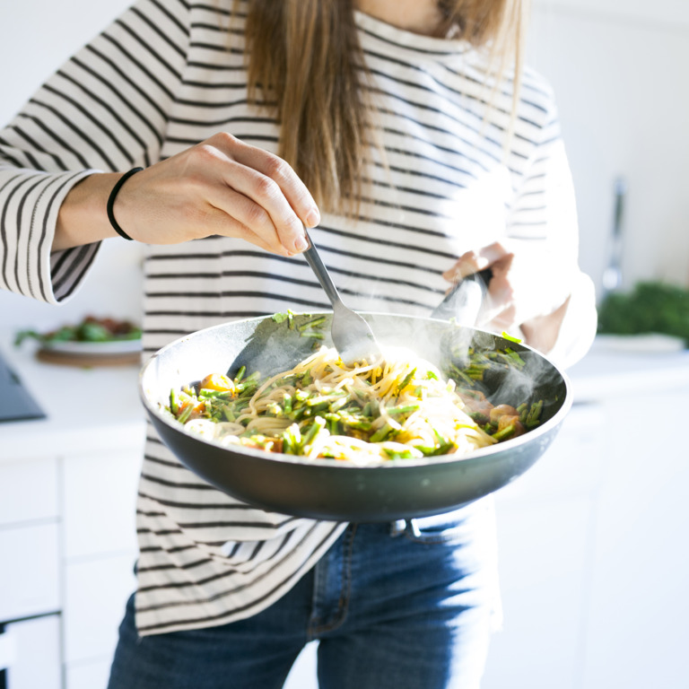 Frau hält eine Pfanne mit Essen